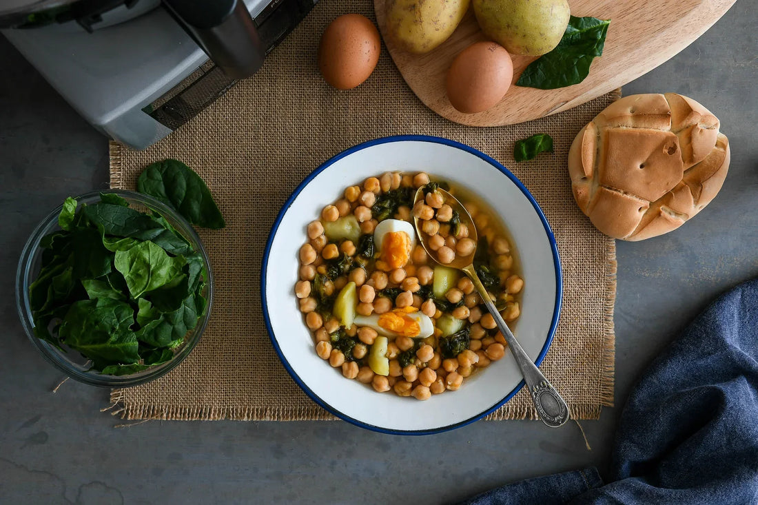 Potaje de garbanzos ecológicos con espinacas y huevo campero servido en plato tradicional