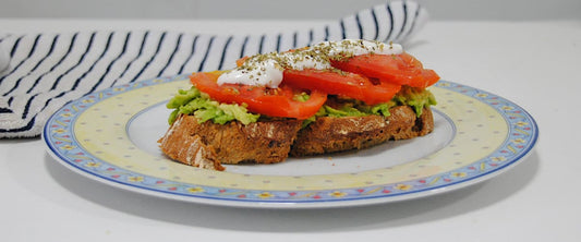 Tosta de tomate Rebelión con queso fresco y aguacate sobre pan tostado