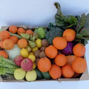 Caja de frutas y verduras ecológicas de temporada Sabores del Pueblo en mesa rústica